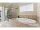 Bright bathroom with a soaking tub, glass shower, and tile surround at 5301 Meadowcroft Way, Fort Mill, SC 29708