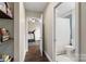 Hallway with wood floors leads to a bathroom with blue tile and a exercise room at 5301 Meadowcroft Way, Fort Mill, SC 29708