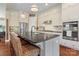 Kitchen island with modern fixtures, stainless steel appliances, and a view of white cabinets at 5301 Meadowcroft Way, Fort Mill, SC 29708