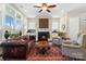 Comfortable living room featuring a fireplace, built-in cabinets, and a beautiful leather sofa at 5301 Meadowcroft Way, Fort Mill, SC 29708