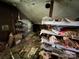 Overstuffed attic featuring low ceilings, shelving, and stored belongings at 6000 S Main St, Salisbury, NC 28147