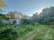 View of an old shed with overgrown vegetation on a sunny day at 6000 S Main St, Salisbury, NC 28147
