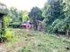 Exterior view of overgrown home in wooded area, surrounded by foliage at 6000 S Main St, Salisbury, NC 28147