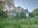 Two story home with gable roof and sunroom is surrounded by overgrown landscaping at 6000 S Main St, Salisbury, NC 28147