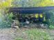 Shed filled with personal items and debris, surrounded by weeds and overgrown grass at 6000 S Main St, Salisbury, NC 28147
