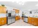 Well-lit kitchen featuring stainless steel appliances, wood cabinets, and an open layout to the living area at 6222 Ohaus Ct # 59, Charlotte, NC 28216