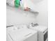 Efficient laundry room featuring a white washer and dryer, complete with a wire shelf for storage and organization at 6222 Ohaus Ct # 59, Charlotte, NC 28216