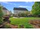 Large backyard with lush green grass, a fire pit, and mature trees at 642 Vega Nw St, Concord, NC 28027