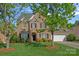 Inviting brick home featuring a manicured lawn, mature trees, and a two-car garage at 642 Vega Nw St, Concord, NC 28027