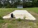 Outdoor slab patio next to storage shed surrounded by grass and trees at 6482 Taylorsville E Hwy, Hiddenite, NC 28636