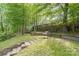 Picturesque backyard featuring mature trees, lush greenery, and a swing set, creating a serene outdoor oasis at 6617 Wannamaker Ln, Charlotte, NC 28226