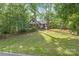 Traditional brick home with a lush, tree-filled front yard on a sloping lawn at 6617 Wannamaker Ln, Charlotte, NC 28226