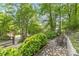 Well-maintained front yard featuring lush greenery, a stone pathway, and mature trees, enhancing curb appeal at 6617 Wannamaker Ln, Charlotte, NC 28226