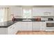 Bright kitchen featuring white cabinets, black countertops, and modern appliances at 6617 Wannamaker Ln, Charlotte, NC 28226