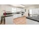 A well-lit kitchen featuring white cabinetry, black countertops, and tile flooring at 6617 Wannamaker Ln, Charlotte, NC 28226