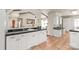 Bright kitchen with white cabinetry, tile floors, black countertops, and an open layout at 6617 Wannamaker Ln, Charlotte, NC 28226