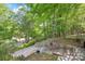 Lush landscaping with stone steps and mature trees, creating a serene and private outdoor space at 6617 Wannamaker Ln, Charlotte, NC 28226