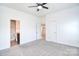 Spacious bedroom with ceiling fan, neutral carpet, and access to an ensuite bathroom at 6631 Vlosi Dr, Charlotte, NC 28226