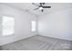 Spacious bedroom with ceiling fan, neutral carpet, and two windows providing lots of natural light at 6631 Vlosi Dr, Charlotte, NC 28226