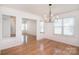 Bright dining room featuring hardwood floors, large windows, and a modern chandelier at 6631 Vlosi Dr, Charlotte, NC 28226
