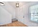 Bright entryway with hardwood flooring, a white door, and a modern light fixture at 6631 Vlosi Dr, Charlotte, NC 28226