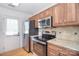 Updated kitchen with stainless steel appliances, granite countertops, and natural wood cabinets at 6631 Vlosi Dr, Charlotte, NC 28226