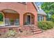 Inviting red brick home exterior featuring a covered porch with chairs and brick stairs leading to the entrance at 709 Myrtle Dr, Rock Hill, SC 29730