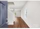 Bright foyer featuring hardwood floors, an open staircase, and natural light streaming through a nearby window at 7113 Amberly Hills Rd, Charlotte, NC 28215
