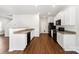 Bright kitchen features white cabinets, granite counters, black appliances, and wood-look flooring at 7113 Amberly Hills Rd, Charlotte, NC 28215