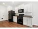 This bright kitchen features white cabinets, granite counters, and black appliances at 7113 Amberly Hills Rd, Charlotte, NC 28215