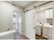 Convenient laundry room with modern washer and dryer, sliding barn door, and attractive backsplash at 7113 Amberly Hills Rd, Charlotte, NC 28215