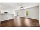 Open-concept living room featuring hardwood floors, a modern ceiling fan, and seamless flow to kitchen and outdoor patio at 7113 Amberly Hills Rd, Charlotte, NC 28215