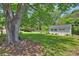 Large backyard featuring a shed, mature trees, and lush greenery, offering ample outdoor space at 751 Lansdowne Rd, Charlotte, NC 28270