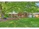 Expansive backyard featuring a well-maintained lawn, mature trees, and a charming brick patio area at 751 Lansdowne Rd, Charlotte, NC 28270