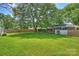 Lush green backyard with mature trees, featuring a charming shed and a serene outdoor atmosphere at 751 Lansdowne Rd, Charlotte, NC 28270