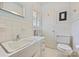 Bathroom featuring tiled walls, single sink vanity, and toilet at 751 Lansdowne Rd, Charlotte, NC 28270