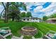 Private backyard with a firepit and chairs on a lush, green lawn at 8330 Fallsdale Dr, Charlotte, NC 28214