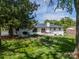 Wide backyard view featuring a patio seating area and blooming flowerbeds at 8330 Fallsdale Dr, Charlotte, NC 28214