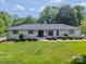 Charming one-story home with manicured lawn, inviting entry, and black framed windows at 8330 Fallsdale Dr, Charlotte, NC 28214