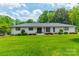 Charming single-story home boasting fresh landscaping, a manicured lawn and dark trim at 8330 Fallsdale Dr, Charlotte, NC 28214