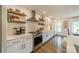Well-lit kitchen with white cabinetry, stainless steel appliances, and stylish open shelving at 8330 Fallsdale Dr, Charlotte, NC 28214