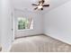 Bedroom has neutral carpet, ceiling fan, one window to the outside, and white walls at 8921 Magnolia Heights Ct, Charlotte, NC 28270