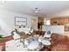 Open-concept living room with hardwood floors, white furniture, and views to the kitchen area at 8921 Magnolia Heights Ct, Charlotte, NC 28270