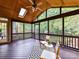 Screened porch overlooking wooded backyard with wood-paneled ceiling, dark wood floor and ceiling fan at 8921 Magnolia Heights Ct, Charlotte, NC 28270