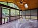 Screened porch overlooking backyard with wood-paneled ceiling, dark wood floor, and ceiling fan at 8921 Magnolia Heights Ct, Charlotte, NC 28270