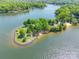 Picturesque aerial shot of a charming waterfront peninsula with sandy shores and green landscapes at 9012 Windjammer Dr, Tega Cay, SC 29708