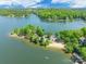 Majestic aerial perspective of a waterfront property with a private beach and lush, mature trees at 9012 Windjammer Dr, Tega Cay, SC 29708
