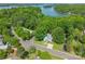 Stunning aerial view of a lakeside home surrounded by lush greenery and serene waters at 9012 Windjammer Dr, Tega Cay, SC 29708