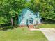 Charming two-story home with a blue exterior, brick stairs, and a lush green lawn, nestled among mature trees at 9012 Windjammer Dr, Tega Cay, SC 29708