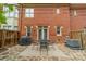 Private back patio with stone floor, dining table, grill, and brick wall at 984 Park Slope Dr, Charlotte, NC 28209
